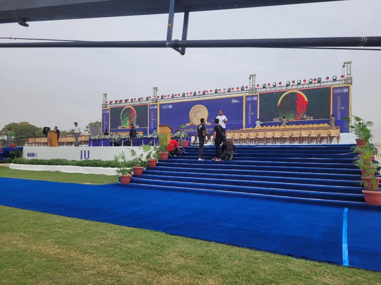 An outdoor stage approached by a blue-carpeted stairway.